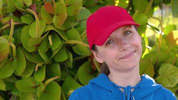 Portrait of pretty woman with red hat outdoors in sunny day closeu video