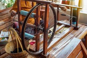 antique winding machine It is a tool for winding the yarn into the spool for a weft line to be put into the weaving shuttle with a loom. photo