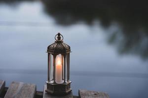 Ramadán Kareem, Arábica linterna con ardiente vela con borroso natural imagen de fondo para festivo saludo tarjeta, invitación para musulmán santo mes, eid mubarak, eid Alabama adha, eid Alabama fitr foto