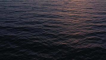 Aerial view of surface of the Atlantic Ocean with reflection of sunlight at sunset video