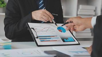 Financial analysts analyze business financial reports on a digital tablet planning investment project during a discussion at a meeting of corporate showing the results of their successful teamwork. video