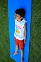 Asian smart kid doing yoga pose in the society park outdoor, Children's yoga pose. The little boy doing Yoga and meditation exercise. photo