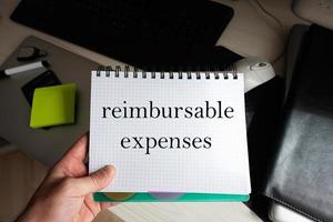Reimbursable expenses word on notebook holding man against desktop. photo