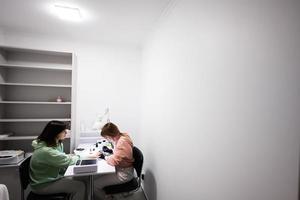 Manicure master working with female client in beauty salon. Manicurist makes woman nail. photo