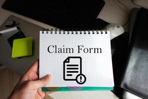 Claim form word on notebook holding man against desktop. photo
