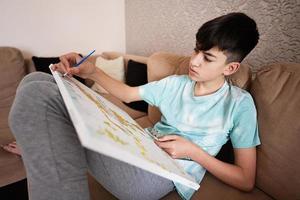 joven masculino adolescente pintura imagen por números en lona en vivo habitación a hogar. pasatiempo y ocio concepto. foto