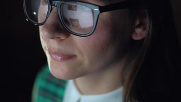 mujer en lentes mirando en el monitor y surf Internet. el monitor pantalla es reflejado en el lentes video