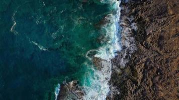 oben Aussicht von ein verlassen Küste. felsig Ufer von das Insel von Teneriffa. Antenne Drohne Aufnahmen von Meer Wellen erreichen Ufer video