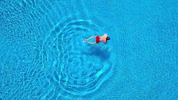 Aerial view of man in red shorts swims in the pool video