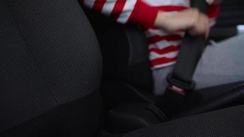 Woman fastening car safety seat belt while sitting inside of vehicle before driving video