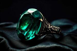 Platinum ring with an emerald gemstone on a cerne background. . photo