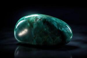 Jade is a rare precious natural geological stone eremite on a black background in low key. . photo