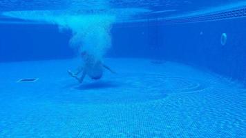 unter Wasser Schießen wie ein Mann Tauchgänge in das Schwimmbad und schwimmt unter das Wasser video