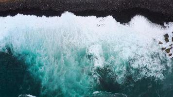 superiore Visualizza di un' abbandonato nero vulcanico spiaggia. costa di il isola di tenerife. aereo fuco metraggio di mare onde raggiungendo riva video