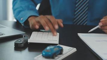 fermer de asiatique femelle signature voiture Assurance document ou bail papier Contrat ou accord. achat ou vente Nouveau ou utilisé véhicule avec voiture clés sur tableau. video