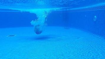 submarino disparo como un hombre inmersiones dentro el piscina y nada debajo el agua video