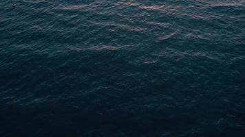 Aerial view of surface of the Atlantic Ocean with reflection of sunlight at sunset video