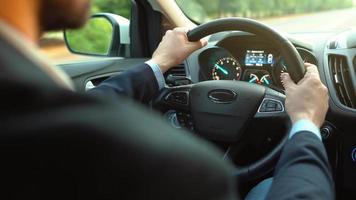 Man driving a car on the road in sunny weather and losing control during the ride. View from behind the driver video