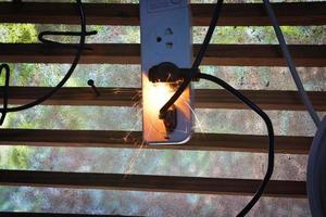 eléctrico enchufe chispas y ardiente causado por un corto circuito, concepto, peligro desde utilizando no estándar equipo, defectuoso equipo foto