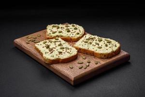 Grilled toast with avocado paste, eggs, cream cheese, salt, spices and herbs photo