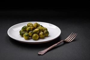 delicioso hervido Bruselas coles en un cerámico plato en un oscuro hormigón antecedentes foto