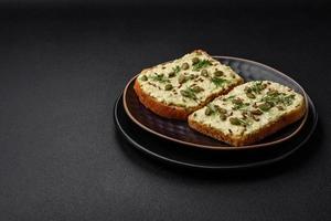 Grilled toast with avocado paste, eggs, cream cheese, salt, spices and herbs photo