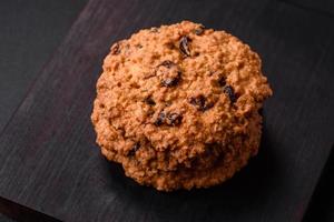 delicioso horneado harina de avena pasa galletas en un oscuro hormigón antecedentes foto