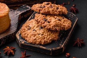 delicioso horneado harina de avena pasa galletas en un oscuro hormigón antecedentes foto