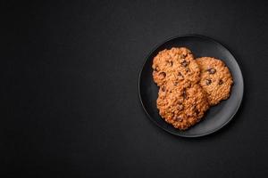 delicioso horneado harina de avena pasa galletas en un oscuro hormigón antecedentes foto