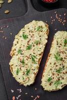 Grilled toast with avocado paste, eggs, cream cheese, salt, spices and herbs photo