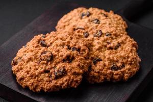 delicioso horneado harina de avena pasa galletas en un oscuro hormigón antecedentes foto