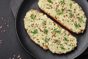Grilled toast with avocado paste, eggs, cream cheese, salt, spices and herbs photo