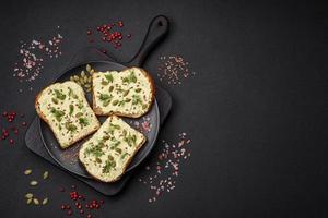 Grilled toast with avocado paste, eggs, cream cheese, salt, spices and herbs photo