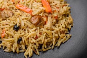 Delicious Uzbek pilaf with chicken, carrots, barberry, spices and herbs photo