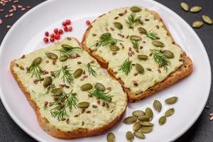 Grilled toast with avocado paste, eggs, cream cheese, salt, spices and herbs photo