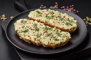 Grilled toast with avocado paste, eggs, cream cheese, salt, spices and herbs photo