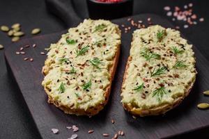Grilled toast with avocado paste, eggs, cream cheese, salt, spices and herbs photo