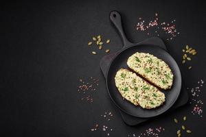 Grilled toast with avocado paste, eggs, cream cheese, salt, spices and herbs photo