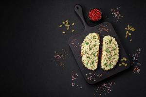 Grilled toast with avocado paste, eggs, cream cheese, salt, spices and herbs photo
