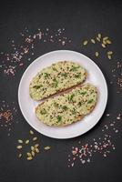 Grilled toast with avocado paste, eggs, cream cheese, salt, spices and herbs photo