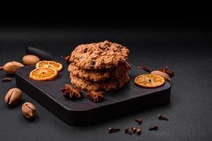 Delicious baked oatmeal raisin cookies on a dark concrete background photo