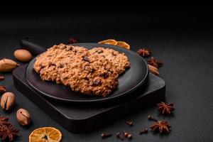delicioso horneado harina de avena pasa galletas en un oscuro hormigón antecedentes foto