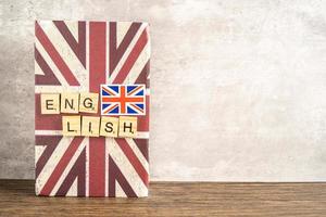 Word English on book with United Kingdom flag, learning English language courses concept. photo