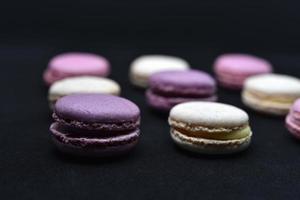 Multicolored cookies on a black background. Macaroni cookies close-up.Delicious and sweet cookies. photo