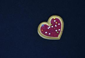 Red heart cookies on a black background. Sweet cookies with a heart. photo