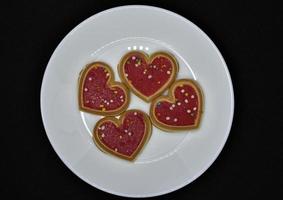 Red heart cookies on a white plate. Sweet cookies with a heart. photo