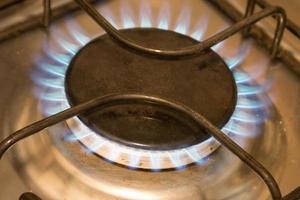 cerca arriba de un gas ardiente estufa en el cocina foto