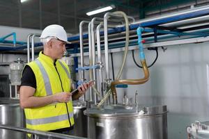 Engineers or factory managers wearing safety helmet inspect the machines in the production line. Utility inspector check machine and test the system to meet the standard. machine, maintenance. photo