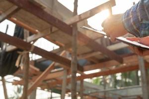inspector or engineer is inspecting construction and quality assurance new house using a checklist. Engineers or architects or contactor work to build the house before handing it over to the homeowner photo