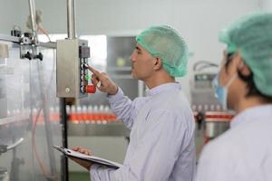 quality supervisor or food or beverages technician inspection about condition control food or beverages before send product to the customer. Production leader recheck machine and productivity. photo